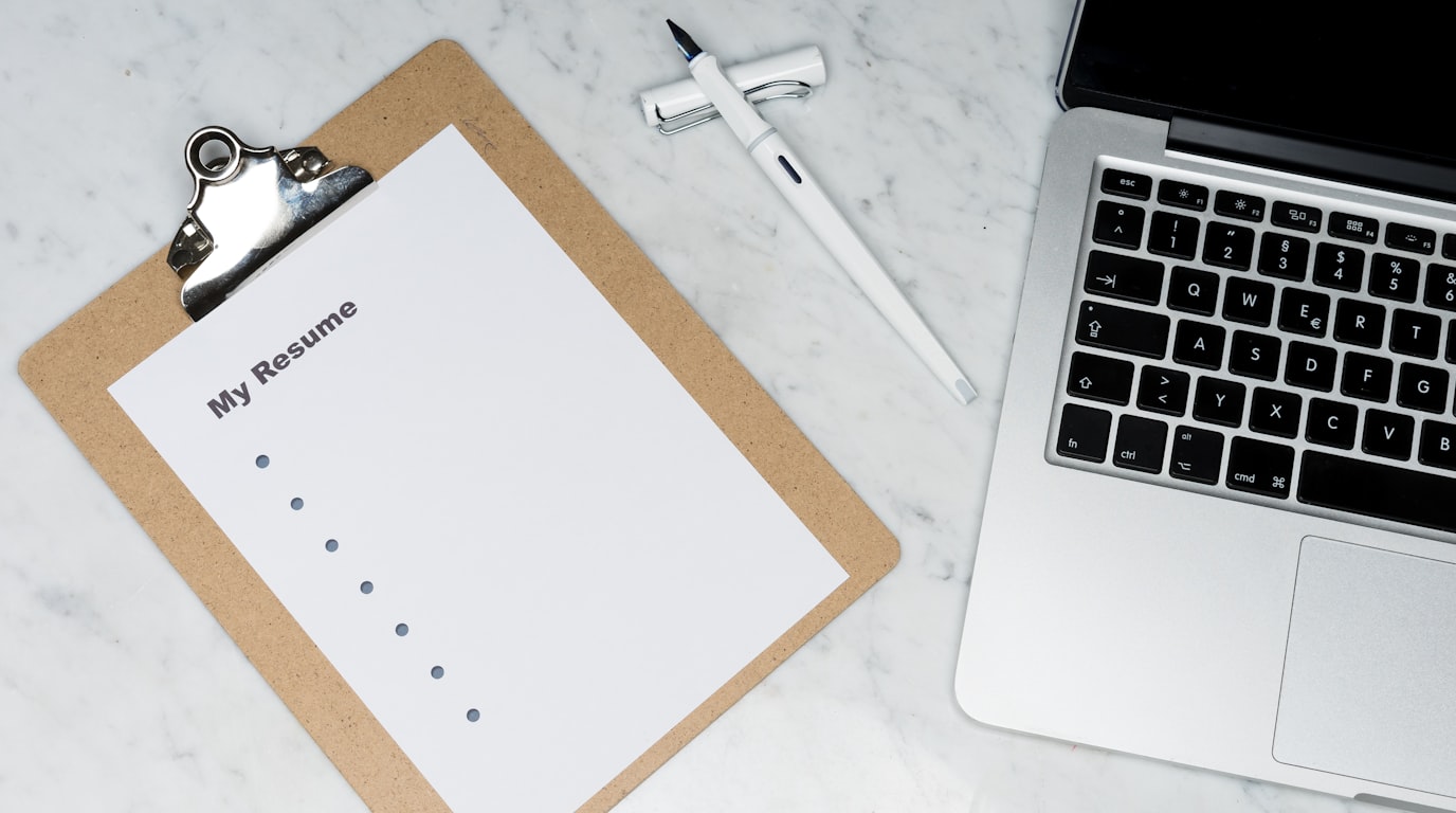 Executive ATS-friendly resume printed on premium paper with fountain pen and modern laptop